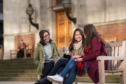 Three women undergraduates enjoying the winter sun at the Dangoor Plaza on the South Kensington Campus