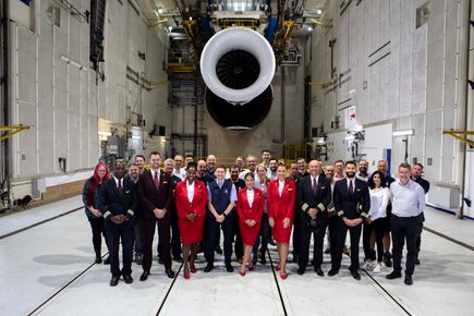 Group of people standing in front of a plane engine