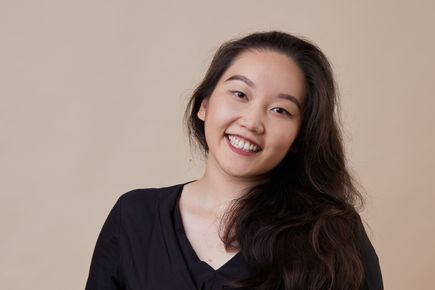 Olivia Ahn smiles at the camera, against a white background