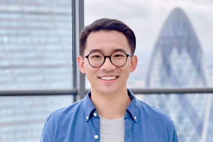 Portrait of Shawn Du, one of the Entrepreneurs' Pledgers, smiling in front of a backdrop of the London skyline