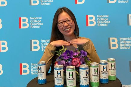 Portrait of Tina Chen, Entrepreneurs' Pledger. smiling with an array of tea drinks in cans