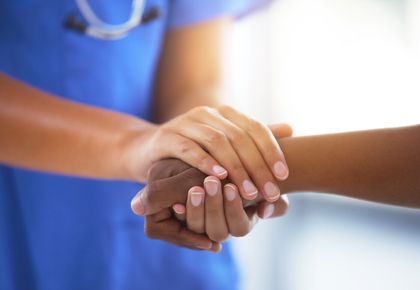 A doctor holding hands with a patient