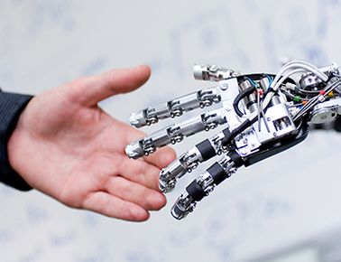 a human hand shaking a robot hand