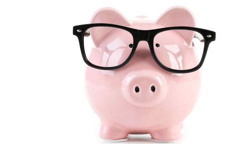 Pink piggy bank with glasses isolated on a white