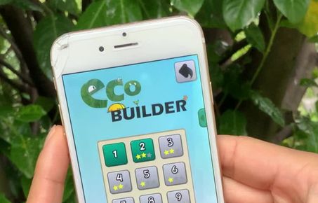 Person playing ecobuilder game on their mobile phone