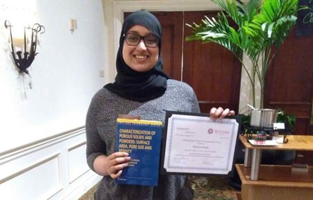 Woman holding a certificate and a book
