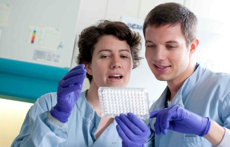 Two NHLI researchers examine a sample in the laboratory