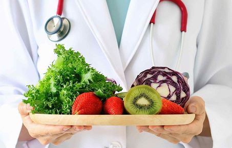 A doctor holding fruit and vegetables