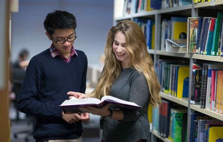 Two students reading a book