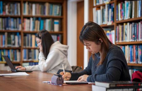 Student writing in library
