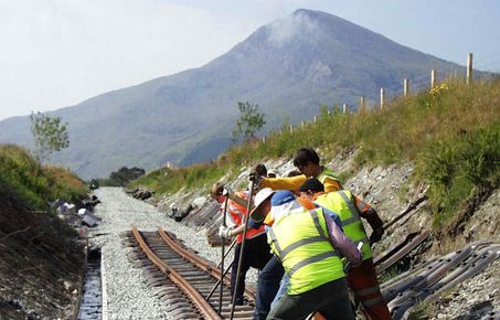 Partially complete railroad being built towards mountain