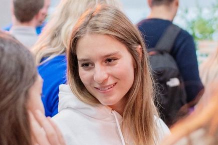 Portrait of Clara Best, one of the Entrepeneur's Pledgers smiling and chatting to people