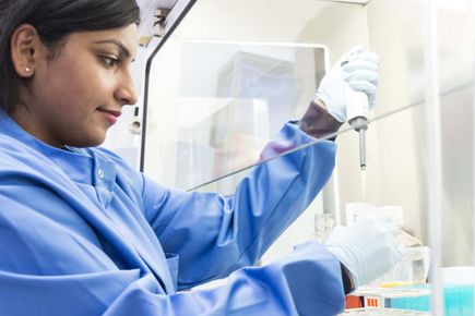 A tudent in lab filing a test tube