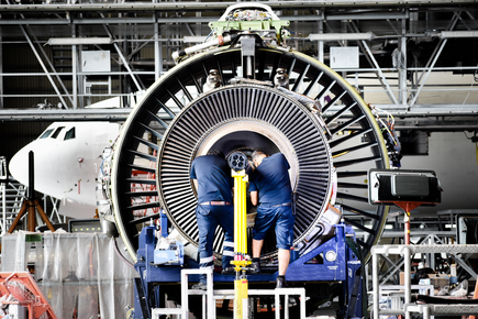 Two engineers working on airplane engine