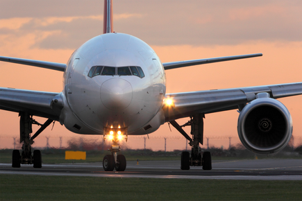 Airplane on runway at sunset