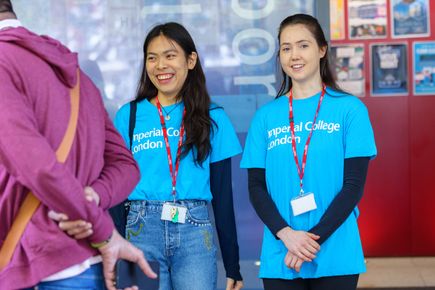 Student helpers in blue T-shirts welcoming new students