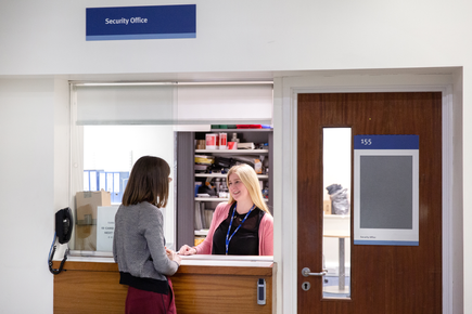 Lady serving student at security reception