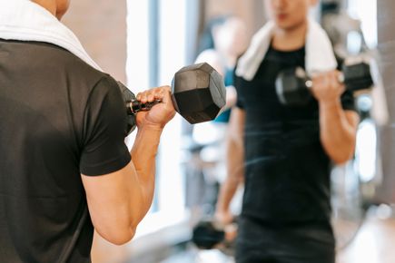 Man lifting weights in a mirror