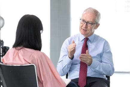 A man gesticulates while talking to a woman