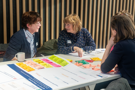 Two women discussing research on a table