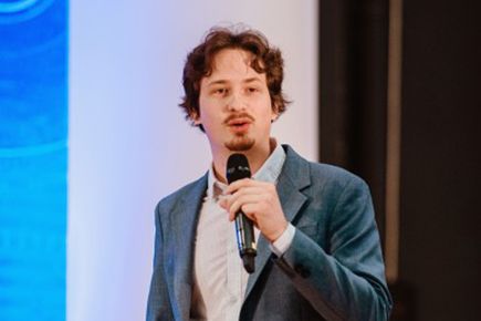 Entrepreneurs' Pledger Martin Holicky gives a presentation in front of a screen, speaking into a microphone