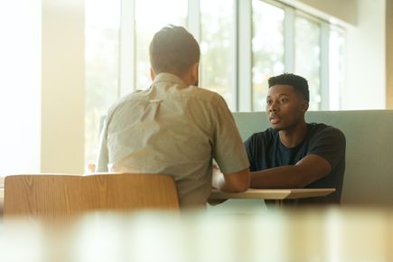 Student sitting talking to professional