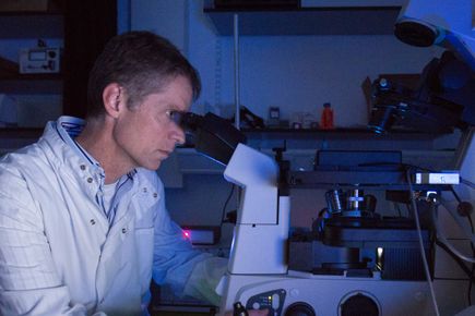 A researcher looking into a microscope