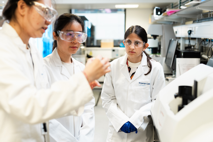 Female engineer explaining something to two other female engineers in a lab