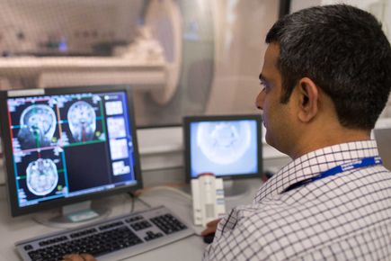 Man looking at an image of a brain scan on computer