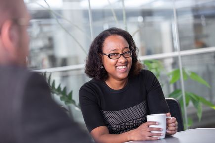 Photo of lady smiling and holding a mug