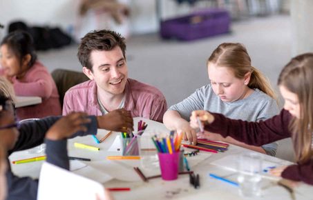 Man helping girls with an activity