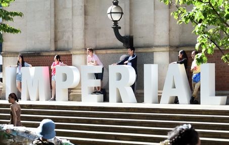 Queens Lawn with people posing behind large letters that spell out 