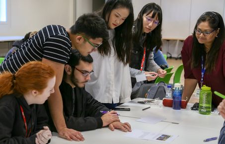 A group of students gathered round a table