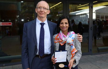 Man and a woman standing side by side and smiling