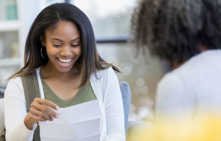 Girl holding a letter and smiling