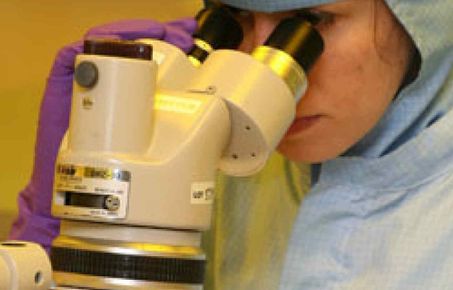 Researcher using clean room equipment