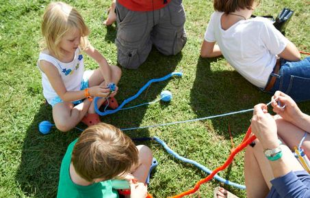 Children knit on lawn