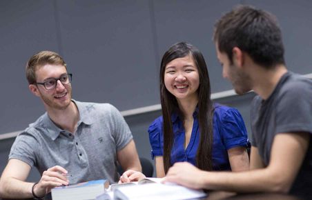 Students discussing texts in a lecture theatre