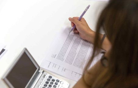 Student writing with a pen