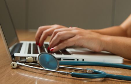 Female doctor typing at laptop