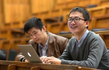 student with laptop smiling