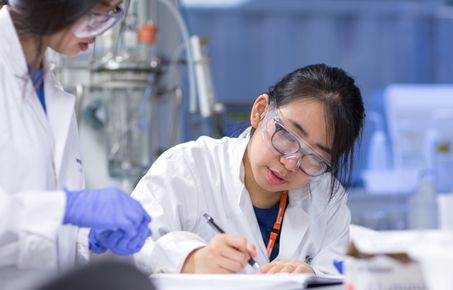 Students writing in a lab