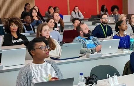 Group of people sitting in lecture theatre for Imperial As One meeting