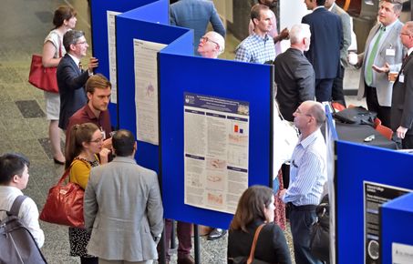 Aerial view of conference attendees networking and looking at posters.