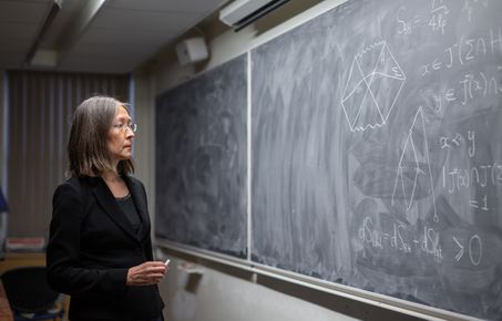 Physicist Fay Dowker looking at equations on a chalkboard