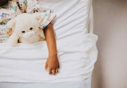 Child with severe anaemia in bed with a toy