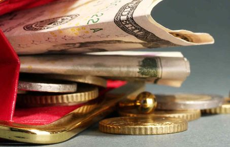 Coins and notes spilling out of purse