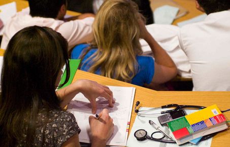 Student taking notes during a lecture