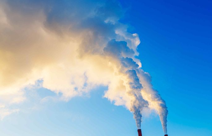 plumes of smoke from power station against blue sky