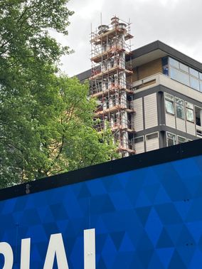 Blue hoardings and behind temporary flues on Skempton building